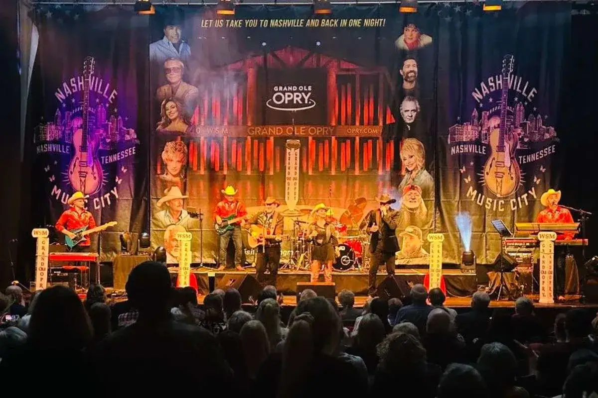 Koncert w Grand Ole Opry, gdzie występują najsłynniejsi wykonawcy muzyki country, z wizerunkami legend na banerze.
