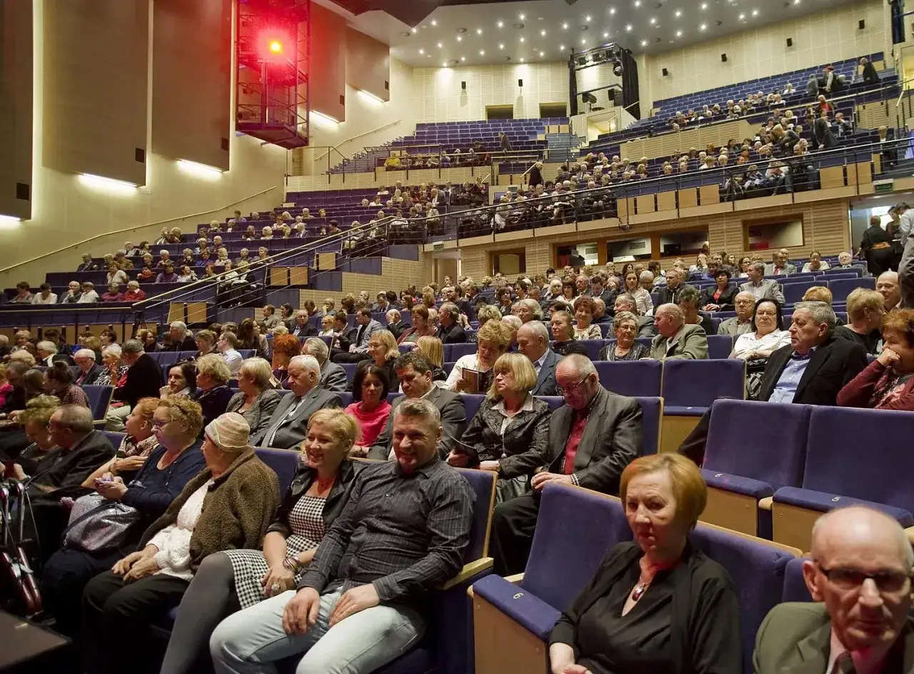 Widownia filharmonii w eleganckich strojach. Zastanawiasz się, jak się ubrać do filharmonii? Tutaj widzisz, że klasyka zawsze się sprawdza.