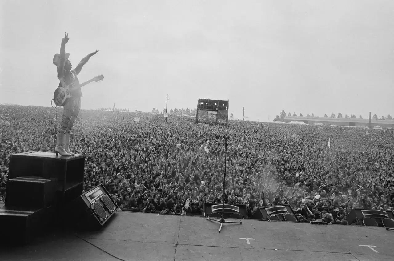 Ogromny tłum na koncercie Metallica Moskwa 1991. Wokalista na scenie, ręce w górze, wita fanów.