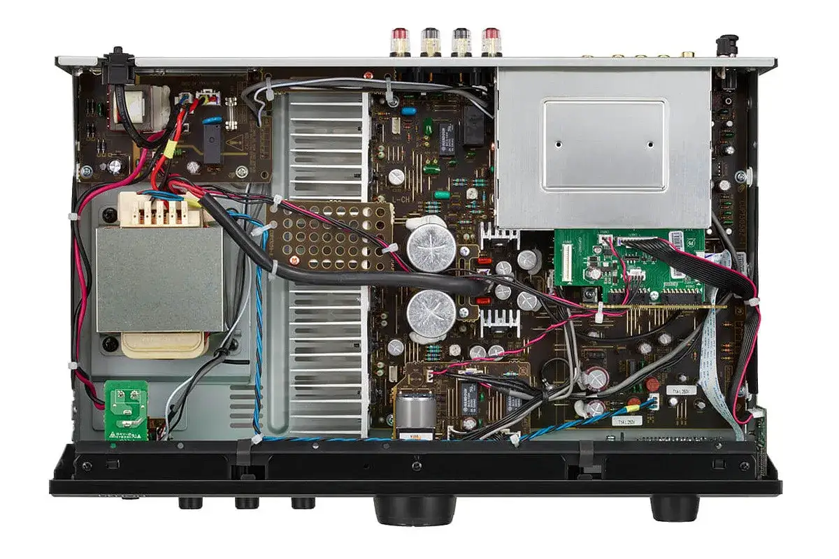 Wnętrze wzmacniacza Denon PMA 600 z widocznym transformatorem, radiatorami i płytkami drukowanymi.