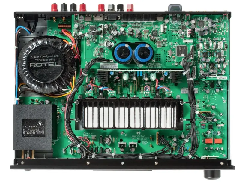 Wnętrze wzmacniacza Rotel A14 MKII z dużym transformatorem i zieloną płytką drukowaną.